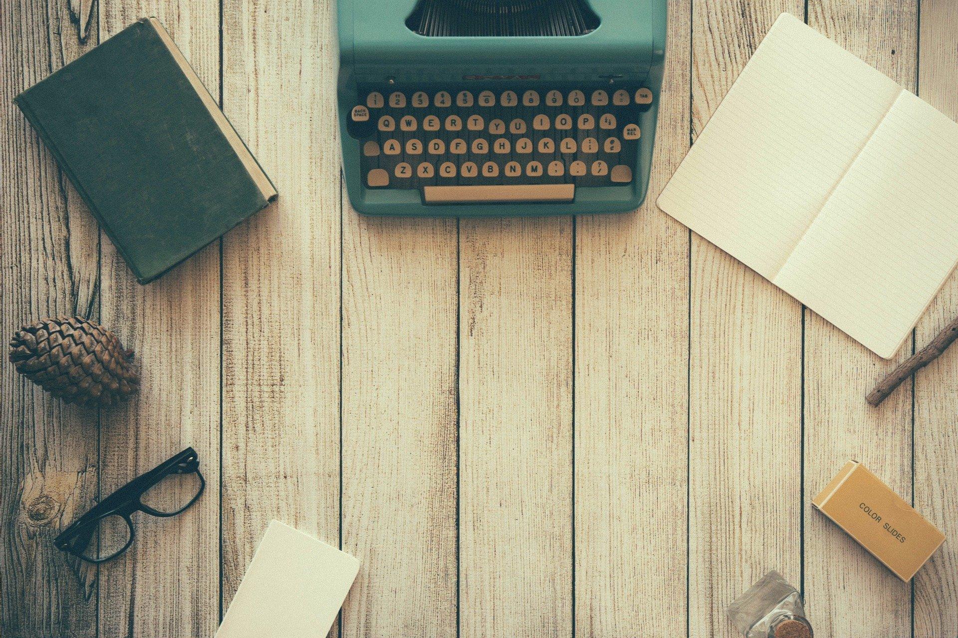 Skrivemaskin, papir og bøker i en ring, fotograf Free-Photos fra Pixabay