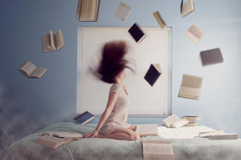 Jente i en seng med masse bøker rundt seg, foto: Pexels fra Pixabay